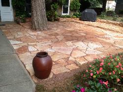 rusty sandstone patio with planter and outdoor grill