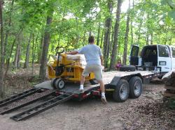 Pallets of stone are unloaded using a rough-terrain pallet jack lowered by a heavy-duty winch.